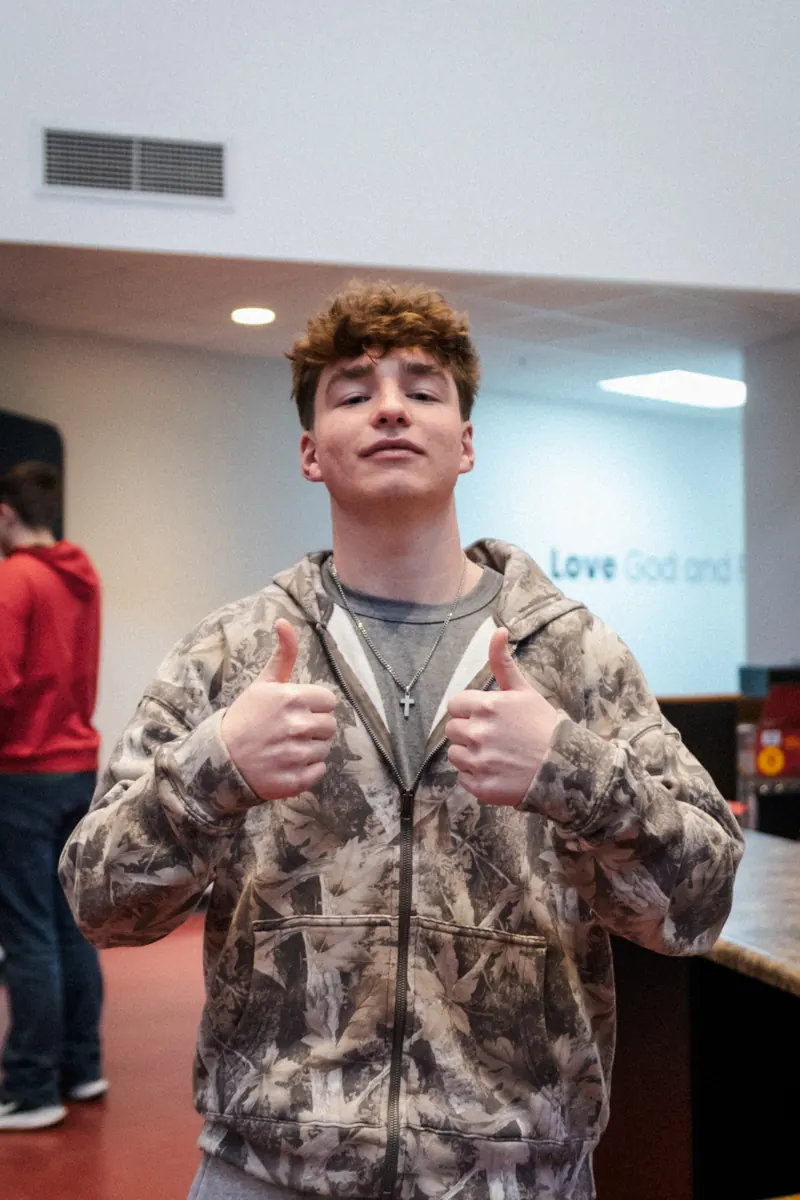 A student giving two thumbs up at youth night